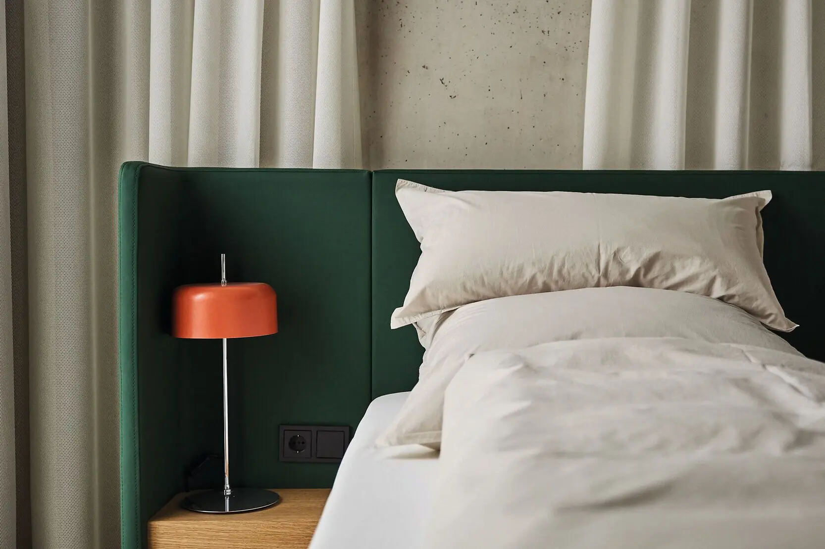 Bed A bed with a bedside lamp in a stylishly furnished bedroom.