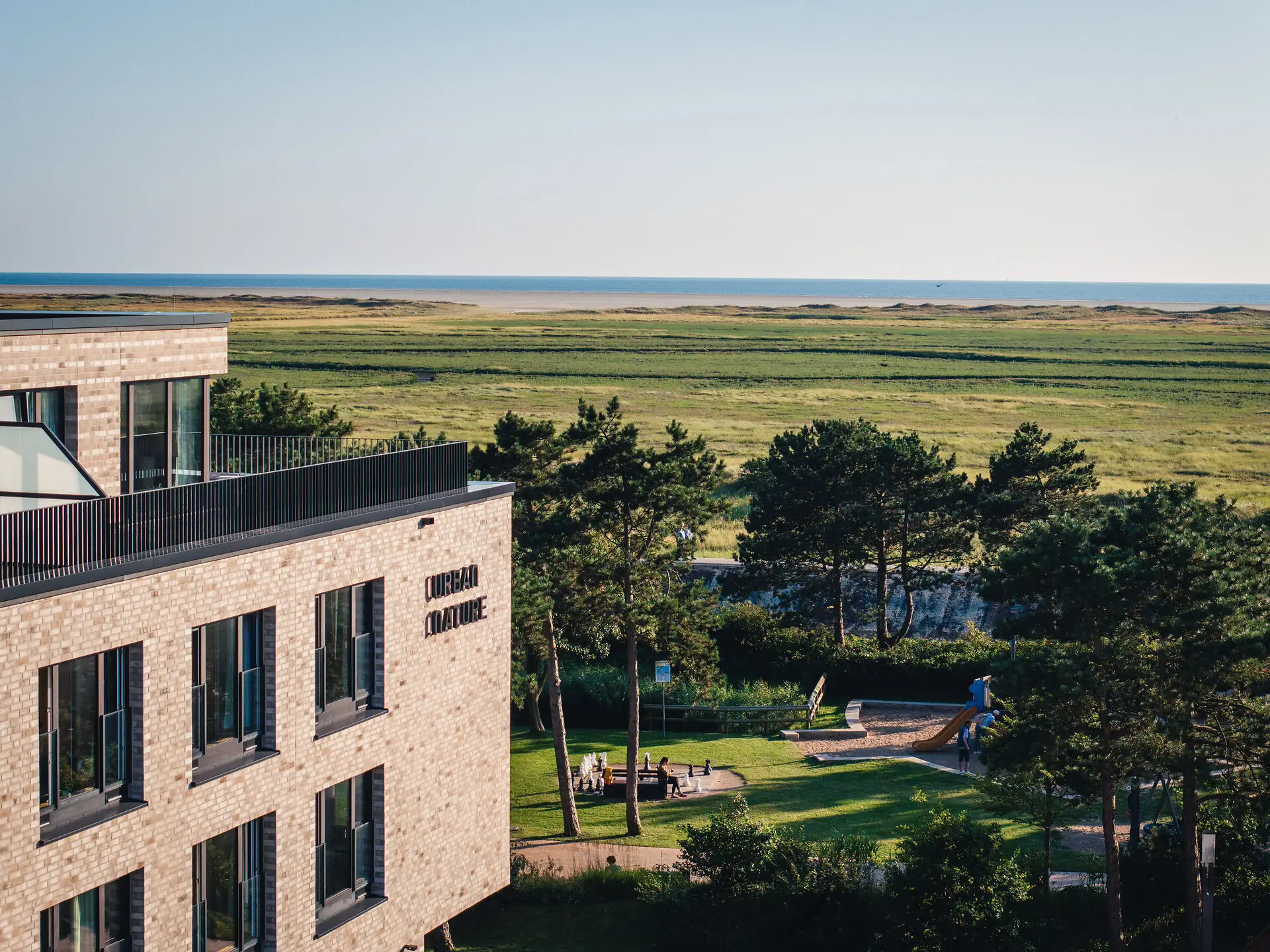 Urban Nature St. Peter-Ording A building with a playground and a grass field.